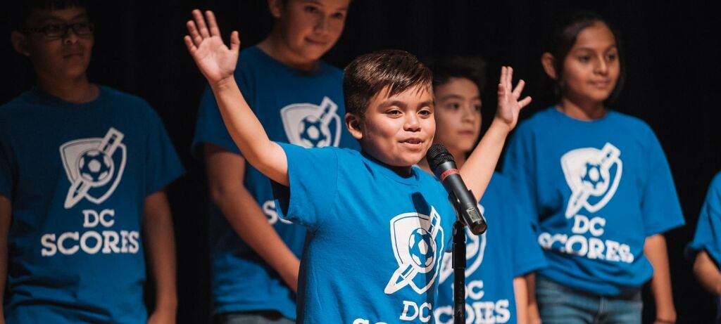 Young, male D.C. scores contestant in front of microphone