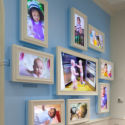 Babies on framed monitors mounted on a light blue wall