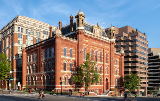 The Planet Word building. It is a historic red brick building with decorative windows, cupolas, and a mansard roof.