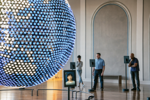 Visitors learning languages on tablets in the Spoken World gallery with a large globe to the left